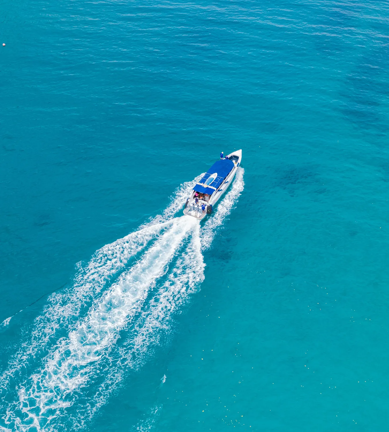 Speedboat crossing deep blue water toward Rok Island